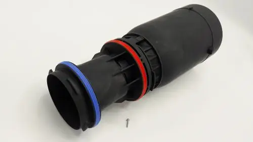 Schwarzes Venturi-Rohr von Remeha mit roten und blauen Dichtungen. Einzelne Schraube liegt neben dem Rohr.